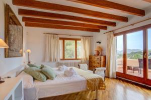 a bedroom with a large bed and a balcony at Villa Zahara in Alcudia