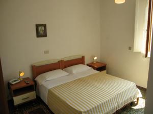 una camera con un letto e due comodini con lampade di Albergo Natucci a Montecatini Terme