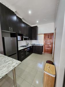 eine Küche mit dunklen Holzschränken und einer Theke in der Unterkunft Villa Marche in Van Riebeekhoogte