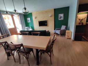 a living room with a wooden table and chairs at Luxueux appartement T4 skis aux pieds à Tignes le Lac in Tignes