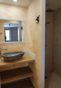 une salle de bain avec un lavabo en pierre et un miroir dans l'établissement COSY EDEN SKI - Luxueux appartement T4 skis aux pieds à Tignes 2100, à Tignes 14 autres photos