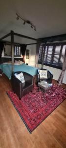 een slaapkamer met een bed en 2 stoelen en een tapijt bij Koasablick in Ebbs