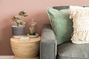 a couch with pillows and a table with plants on it at BOURNECOAST: STYLISH FLAT WITH SEA GLIMPSES - FM8405 in Southbourne