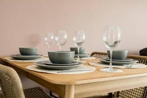 a wooden table with plates and wine glasses on it at BOURNECOAST: STYLISH FLAT WITH SEA GLIMPSES - FM8405 in Southbourne