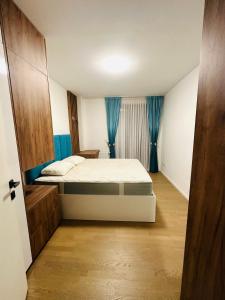 Schlafzimmer mit einem Bett und blauen Vorhängen in der Unterkunft Sarajevo Exclusive Apartment with Free garage in Sarajevo