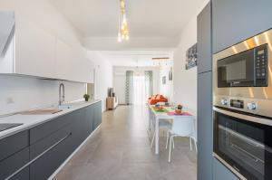 eine Küche mit einem Tisch und einer Arbeitsplatte in der Unterkunft Catania Roomy & Modern Apartment - Balconies in Catania