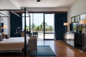 a bedroom with a canopy bed and a balcony at The Blue Water in Wadduwa