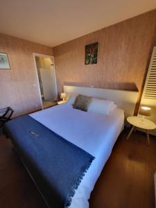 ein Schlafzimmer mit einem großen weißen Bett mit einer blauen Decke in der Unterkunft Rysselende Molen in Ardooie