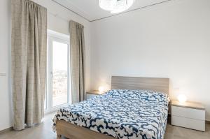 ein Schlafzimmer mit einem Bett und einem großen Fenster in der Unterkunft Catania Roomy & Modern Apartment - Balconies in Catania
