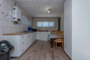 a kitchen with white cabinets and a table and chairs at Vista da Montanha in Gansbaai