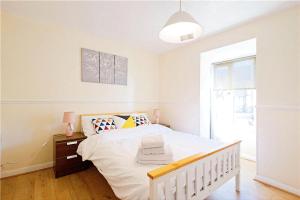 um quarto branco com uma cama branca e uma janela em Manor Place Apartment Thamesmead em Thamesmead