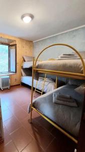 a room with three bunk beds and a window at Appartamento Abetone vicino alle piste da sci! in Abetone