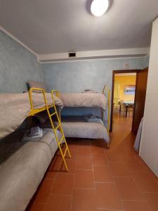 une chambre avec deux lits et une étagère jaune dans l'établissement Appartamento Abetone vicino alle piste da sci!, à Abetone 5 autres photos