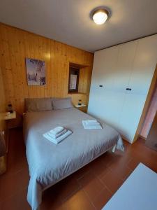 a bedroom with a bed with two towels on it at Appartamento Abetone vicino alle piste da sci! in Abetone