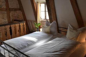 a bedroom with a bed with white pillows and a window at Ickelhaus 2 in Bad Windsheim