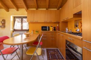 une cuisine avec des armoires en bois et une table et des chaises dans l'établissement Apartment By the Ferry - Menaggio, à Menaggio 9 autres photos