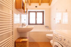 La salle de bains est pourvue d'un lavabo, de toilettes et d'une baignoire. dans l'établissement Apartment By the Ferry - Menaggio, à Menaggio