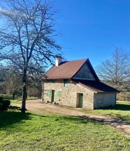 una vecchia casa di pietra in un campo con un albero di Morvan La Pastourelle a Quarré-les-Tombes
