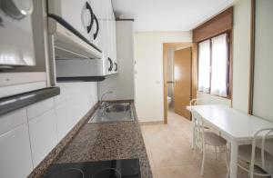 a kitchen with a sink and a table at Apartamentos Mugarri in Poveña