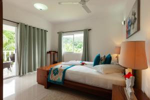 a bedroom with a large bed and a large window at Casa Tara Villas in Grand'Anse Praslin