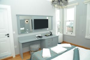 a room with a desk with a tv on a wall at CK SULTANAHMET HOTEL in Istanbul
