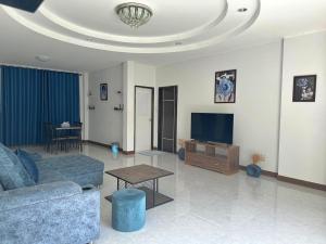 uma sala de estar com um sofá e uma televisão em Baan Fah Chiang Rai em Mae Salong Nai