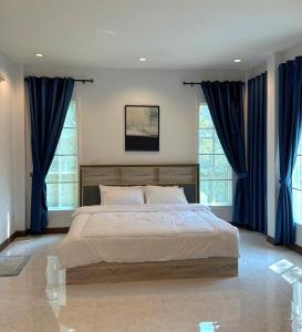 um quarto com uma cama grande e cortinas azuis em Baan Fah Chiang Rai em Mae Salong Nai
