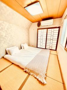 a bedroom with a bed in a room with a window at YUYUSO Hostel in Tokyo