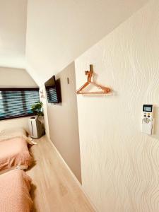 niewielka sypialnia z łóżkiem i oknem w obiekcie YUYUSO Hostel w Tokio