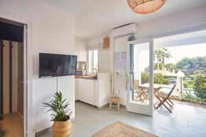 a kitchen with a refrigerator and an open door to a patio at OasisBlanc Binibeca in Binibeca