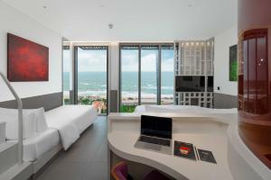 a bedroom with a bed and a laptop on a desk at Wink Hotel Tuy Hoa Beach - 24hrs stay & Rooftop Pool Bar in Tuy Hoa