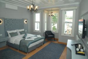 a bedroom with a bed and a desk and windows at CK SULTANAHMET HOTEL in Istanbul