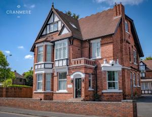 a red brick house with a black roof at Cranmere Lichfield in Lichfield