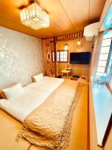 um quarto com uma cama grande e uma janela em YUYUSO Hostel em Tóquio