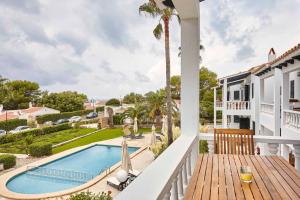 Blick vom Balkon eines Hauses auf den Pool in der Unterkunft Binibeca Blanc in Binibeca