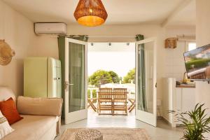 a living room with a door open to a patio at OasisBlanc Binibeca in Binibeca