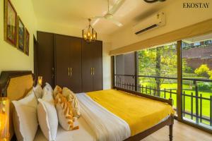 a bedroom with a bed and a large window at EKOSTAY Luxe - Casa Marina in Candolim