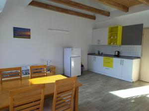 La cuisine est équipée d'une table, d'un réfrigérateur et de placards. dans l'établissement Apartmány Dalov, à Šternberk