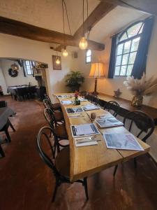een grote eetkamer met een lange tafel met stoelen bij Rysselende Molen in Ardooie
