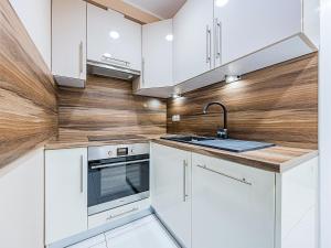a kitchen with white cabinets and a sink at Hello Apartments 4 Oceany z prywatnym parkingiem in Gdańsk