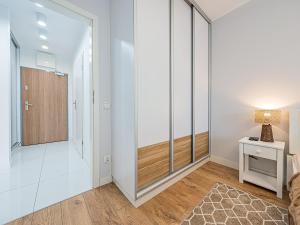 a living room with white walls and a sliding glass door at Hello Apartments 4 Oceany z prywatnym parkingiem in Gdańsk