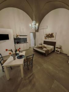 ein großes Wohnzimmer mit einem Bett und einem Tisch in der Unterkunft Soffio del Salento in Matino