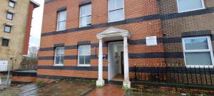 un edificio de ladrillo con una puerta blanca. en Prime Location 1-bedroom apartment - Close to Solent-Hospital-Amazon Voucher for long stay, en Southampton