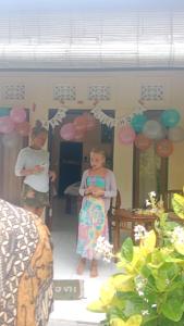 a boy and a girl standing in a room with balloons at Hause market in Sidemen
