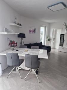 uma sala de estar com uma mesa branca e cadeiras em Ferienwohnung Alona em Engelsbrand