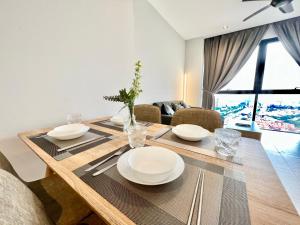 a dining room table with white plates on it at LA 1-10 Pax Cozy Home Tropicana 3Rooms 4QBeds Wifi&TV in Petaling Jaya