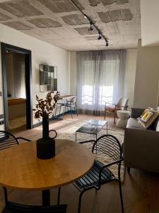 un soggiorno con tavolo, sedie e divano di Bubu - Nuevo edificio de apartamentos en el centro a Málaga