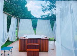 a bath tub sitting on a patio with white curtains at Pousada Jupter in Teresópolis