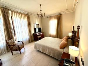 a bedroom with a bed and a chair and a television at Hotel Kazar in Ontinyent