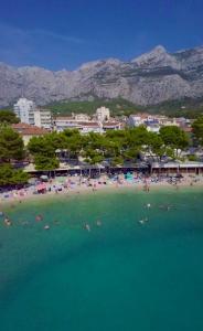een strand met een stel mensen in het water bij Apartment Mucrum in Makarska